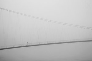 Solitary Walk on Foggy Bridge