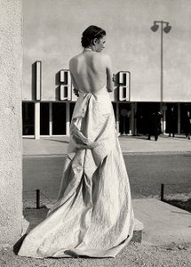 Model seen from the back wears an evening dress created by the couture house "Lamma" by Luis Bogino