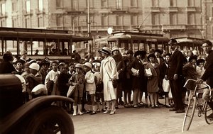A group of students during a fieldtrip. The photograph shows the children, their teachers and other pedestrians on city street by Mario Castagneri