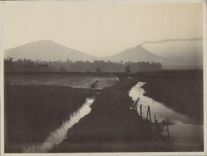 Man Working on the Land at the Foot of a Smoking Volcano