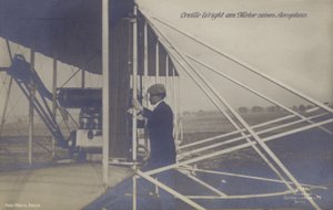 American aviator Orville Wright inspecting the engine of his aeroplane