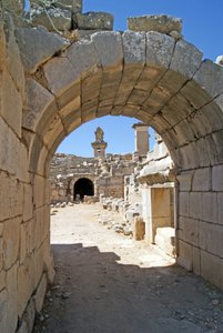 View through the vaulted entrance of the Xanthos theatre into the Orchestra pit, showing pillar and Harpy tomb, Xanthos, Turkey