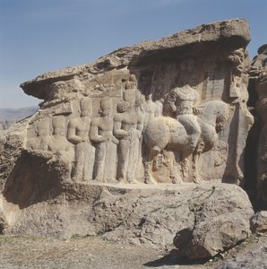 Rock relief depicting Shapur I and his family wearing heraldic emblems on their hats, with a tri-lingual inscription on the horse in Greek, Parthian and Middle Persian