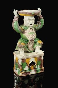 Egg and Spinach Glazed Pricket-Stick, Modelled as a Smiling Immortal with Scrolling Beard, Arms Raised to Support the Quatrefoil Pricket Attachment Balanced on His Head, Kangxi