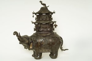 Figure of an elephant wearing a howdah cloth, elaborate surcingle and a pagoda building by Japanese School
