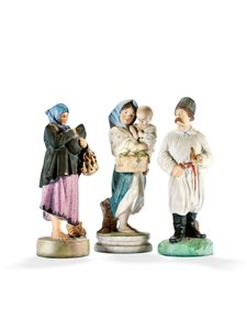 Three porcelain figures depicting two women holding children, and a Cossak with a pipe, late 19th century