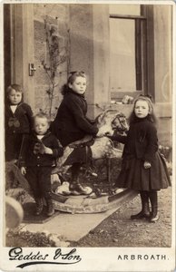 Group of young children and their rocking horse by Scottish Photographer
