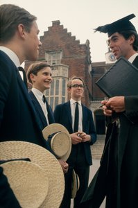 Harrow students consult with a teacher in front of their school