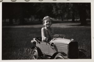 Boy driving a toy pedal car, c 1930