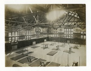 Horizontal Photograph of the Interior of a Large Gym. Equipment and Mats are Spread Out on the Floor