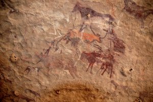 Rock art, Prehistory: Rock painting of a group of cattle and polychrome characters (shepherds and archers) in an ornate shelter, in the Uweinat massif, Sudan. Period from 8000 to 3000 years BC by Unbekannt