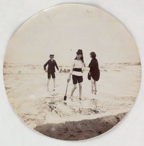 Two girls and a boy paddling in the sea, c 1890