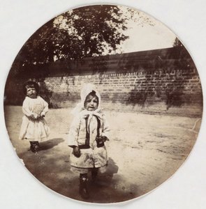 Two small children walking alongside a wall, c 1890 by Unbekannt