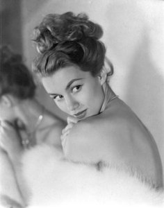 A young woman peers coyly over her shoulder, circa 1948: Winking by Unbekannt