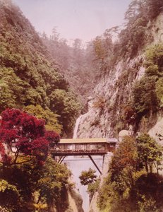 Covered bridge in a steep gorge, with waterfalls in the background, Japan, c.1890-1910 by Unbekannt