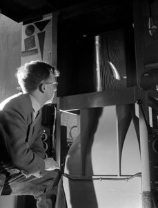 Engineer in wind tunnel with smoke tests under way on a small wing section by Unbekannt