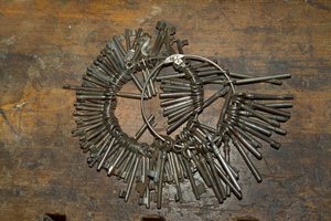 Large bunch of old keys on ring on wooden desk by Unbekannt