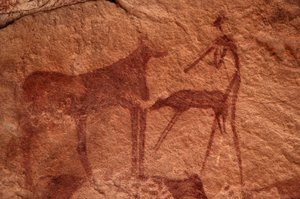 Rock art, Prehistory: Rock painting of a cow, calf and character in an ornate shelter, in the Uweinat massif, Egypt by Unbekannt