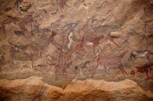 Rock art, Prehistory: Rock painting of a group of cattle and polychrome characters in an ornate shelter, in the Uweinat massif, Sudan. Period from 8000 to 3000 years BC. Photography by Unbekannt