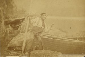 Man Posing Beside Rowboat