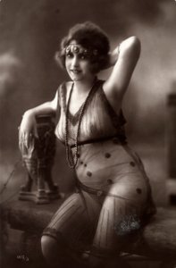 A young woman sitting down, wearing a transparent dress
