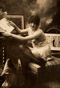 Portrait of a young woman in intimate apparel, seated at a table with a book
