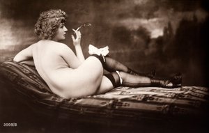 Portrait of a young woman posing naked, with her back turned, as she smokes a cigarette by Unknown photographer