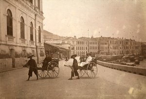 Two men carried by rickshaw in Hong Kong by Unknown photographer