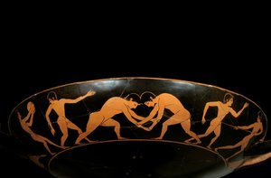 Attic cup with red figures representing athletes in training, a discobole and wrestlers