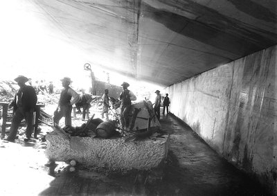 Excavators below the walls of marble in a quarry, in the Apuan Alps by A. Corsini
