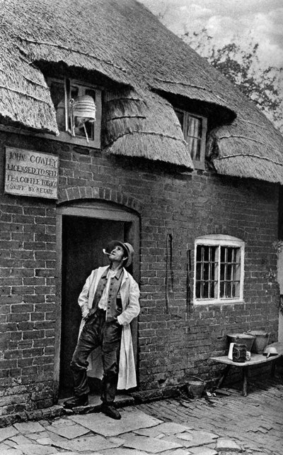 A Man Smoking a Pipe Outside a Shop, Worcestershire by A. W. Cutler