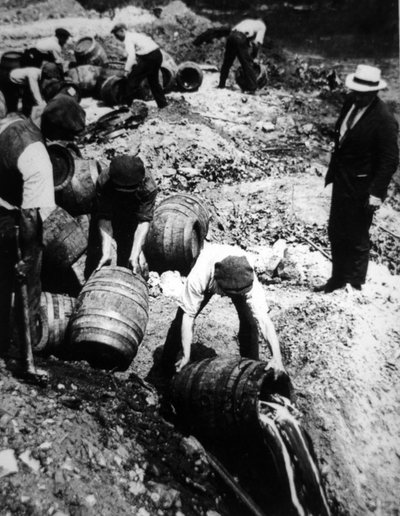 A US Federal Agent oversees the destruction of beer kegs during the American Prohibition era (1920-33) by American Photographer