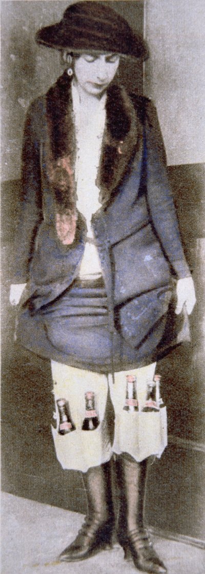 A woman hiding illegal bottles of beer under her skirt in special underwear pockets during the American Prohibition (1920-33) by American Photographer