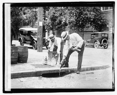 Two Men Pouring Liquor into Storm Drain, 8 July 1921 by American Photographer