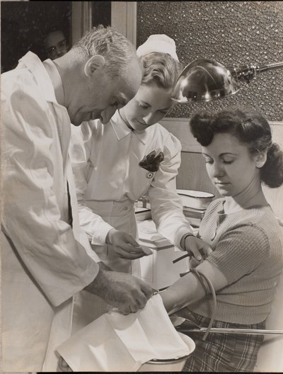 Doctor and nurse inserting a needle into a woman