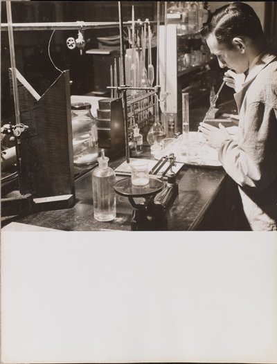 Man in a Lab Using a Large Pipette by Arnold Eagle