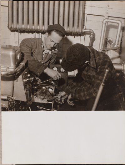 Two Men Work on a Machine Using a Screwdriver and a Wrench by Arnold Eagle