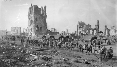 An unidentified Australian Machine Gun section with packed horses passing the ruins of the Cloth Hall. Note several motor lorries parked in the background, 19 October 1917 by Australian Photographer