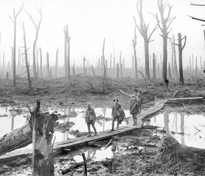 Five Australians, members of a field artillery brigade, passing along a duckboard track over mud and water among gaunt bare tree trunks in the devastated Chateau Wood by Australian Photographer