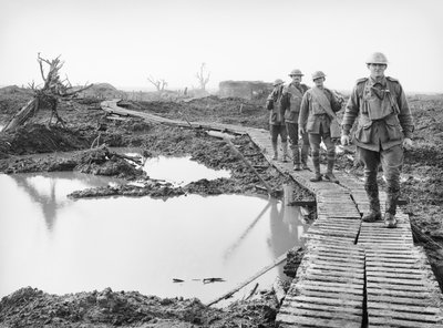 Four Australian soldiers walking along the duckboard track at Tokio, near Zonnebeke, in the Ypres sector, over a portion of the country captured by the Australians in the fighting of the Third Battle by Australian Photographer