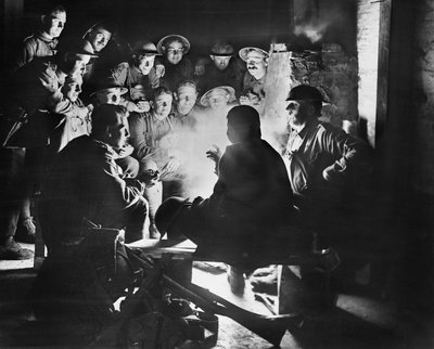 Members of the 1st Australian Light Trench Mortar Battery, 1st Australian Division listening to the latest from one of their comrades around a fire in a dugout billet at Ypres, 28 October 1917 by Australian Photographer
