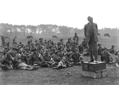 The Right Honourable William Morris (Billy) Hughes, standing on a platform composed of four ammunition boxes, addressing a gathering of the 5th Australian Field Ambulance, near La Motte by Australian Photographer