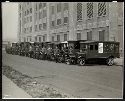 A line of delivery trucks parked outside the Carolyn Laundry at 111 East 128th Street, East Harlem, New York, 1929 by Byron Company