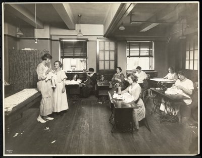 Blind young women and a teacher sewing in a classroom at the New York Association for the Blind, 111 East 59th Street, New York, 1921 by Byron Company