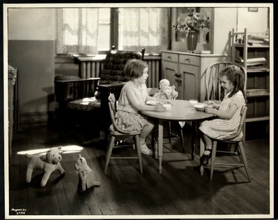 Two blind visually impaired girls eating at a small table with doll at the New York Association for the Blind, 111 East 59th Street, New York, 1933 by Byron Company