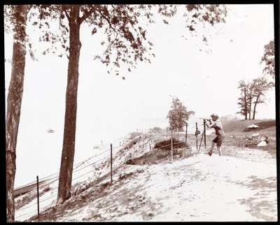 View of a Boy with a Spyglass Looking Toward the Hudson River from Riverside Park, New York by Byron Company
