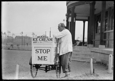 An Eldorado ice cream seller standing beside his tricycle cart outside a pavilion by Charles William Prickett