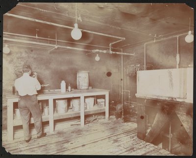Film laboratories at Carlton Motion Picture Co. with five men and one woman working with film, New York by Company Byron