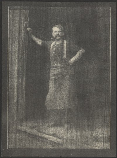 Blacksmith Standing in Doorway, Pipe in Mouth by Doris Ulmann