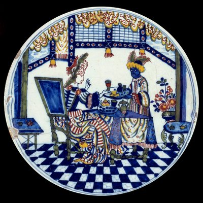 Delft porcelain plate representing a woman at a table served by her black servant by Dutch School